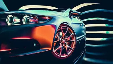 Low-angle shot of a modern car's front quarter, showcasing its multi-spoke wheel. Orange and blue light reflects off the car body against abstract black and white stripes.