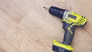 Cordless power drill resting on a wooden surface.