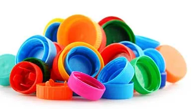 Close-up of colorful plastic bottle caps piled together, showing a variety of sizes, textures, and colors.